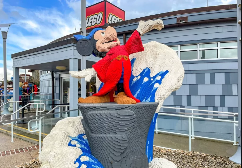Estátua gigante do Mickey Feiticeiro feita de peças LEGO na frente da loja LEGO