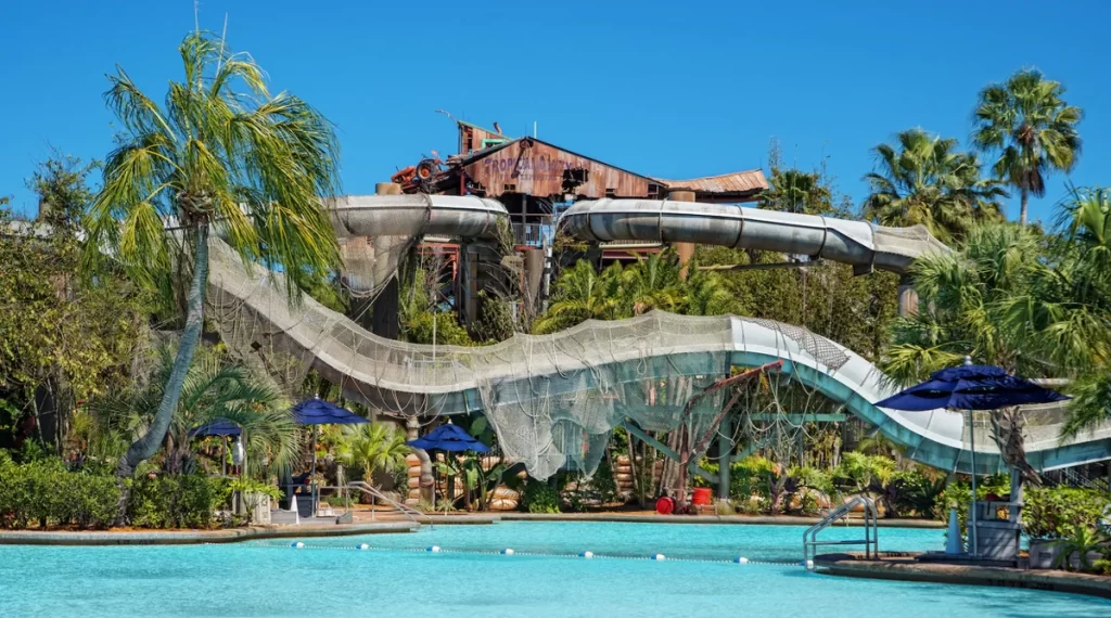 Atração Crush 'n' Gusher no Typhoon Lagoon, com toboáguas entre árvores tropicais.