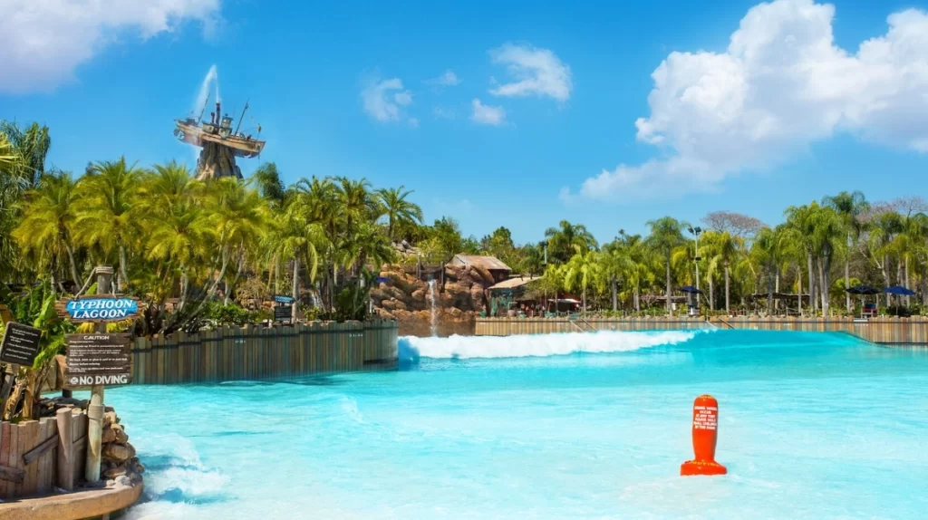 Vista frontal da piscina de ondas do Typhoon Lagoon com palmeiras ao fundo.