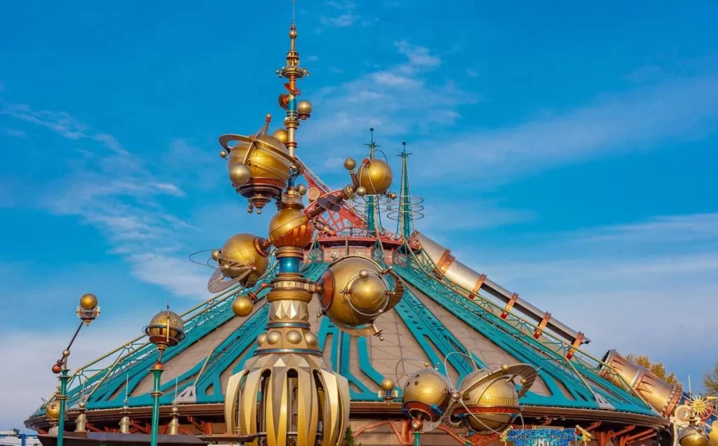 Orbitron em Discoveryland com planetas dourados girando e a Hyperspace Mountain ao fundo