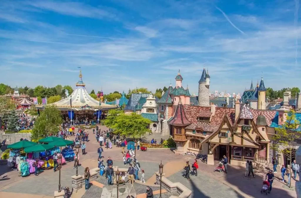 Vista da Fantasyland na Disneyland Paris com arquitetura inspirada em contos de fadas e carrossel ao fundo