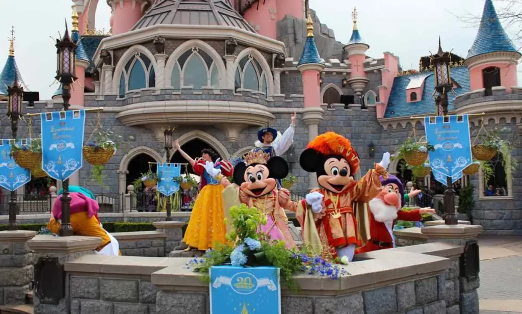 Mickey e Minnie em trajes festivos com o Castelo da Bela Adormecida ao fundo