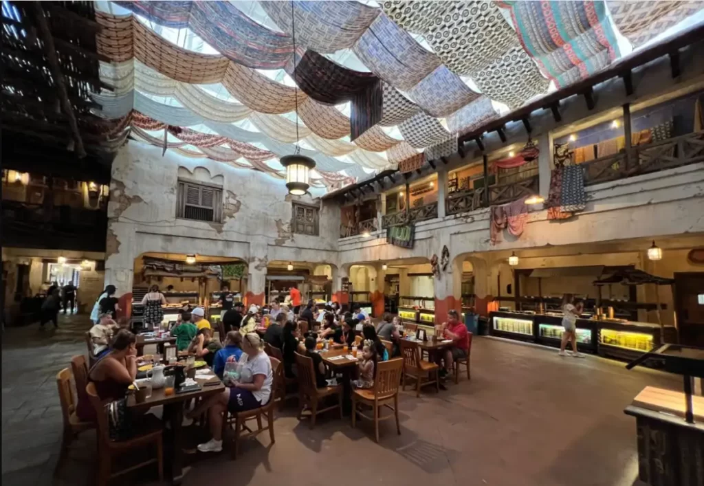 Interior temático do Tusker House com decoração africana e mesas para buffet