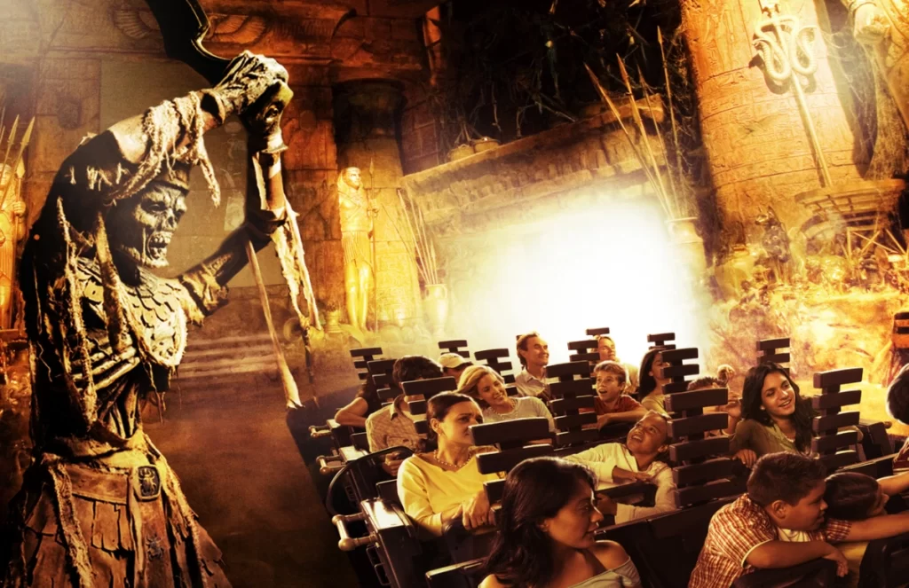 Montanha-russa indoor Revenge of the Mummy com múmia animatrônica e passageiros assustados