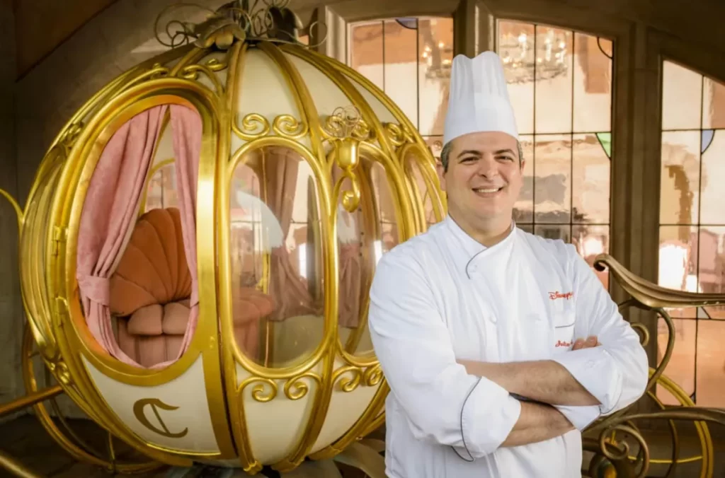 Chef da Disney na frente da carruagem da Cinderela no Auberge de Cendrillon