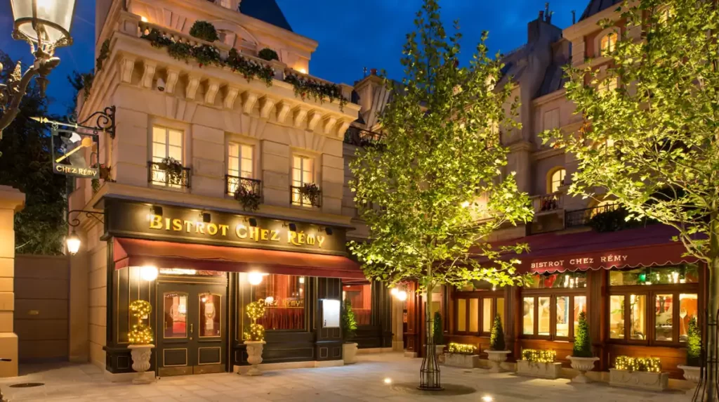 Fachada do restaurante Bistrot Chez Rémy em estilo parisiense iluminado à noite