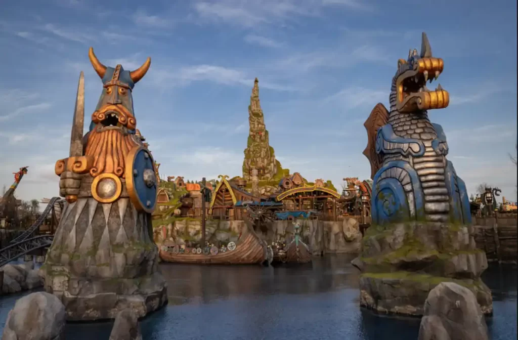 Entrada monumental da Isle of Berk com estátuas vikings e navios temáticos.