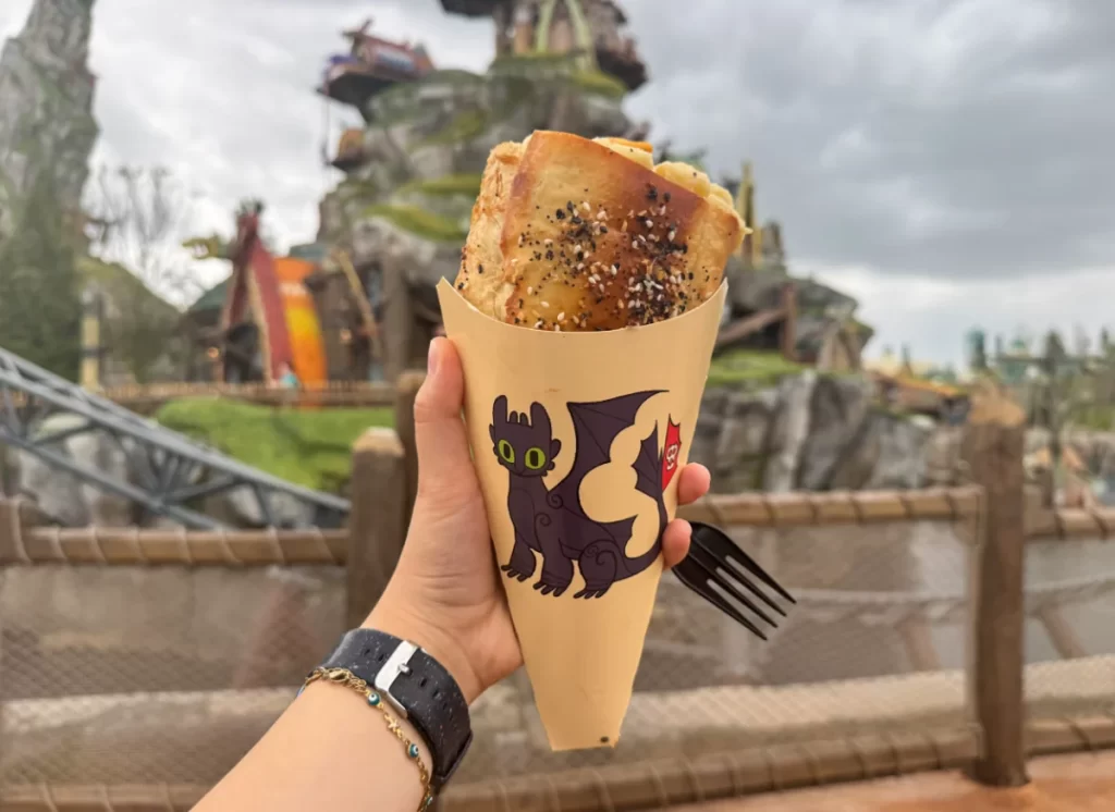 Cone recheado com mac and cheese em embalagem com personagem Banguela na área de Isle of Berk