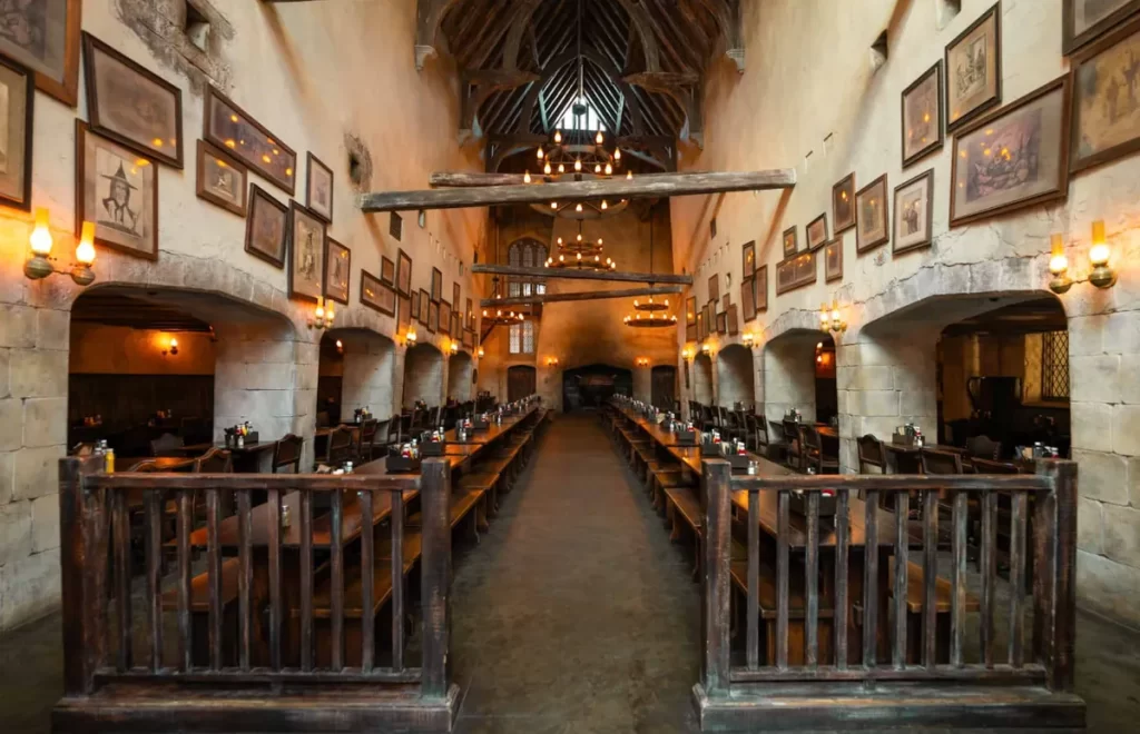 Salão do Three Broomsticks vazio, revelando a arquitetura mágica e imersiva do restaurante.