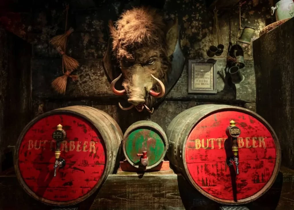 Barris de Butterbeer no Cabeça de Javali, com cabeça de javali taxidermizada e decoração rústica.