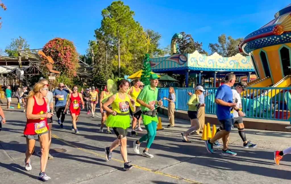 Participantes fantasiados correndo na maratona runDisney dentro do parque temático Walt Disney World.