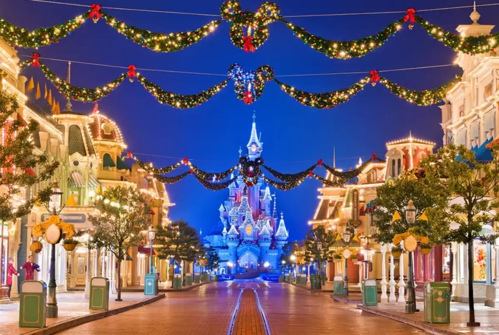 Main Street da Disneyland Paris decorada para o Natal com luzes e Castelo iluminado ao fundo