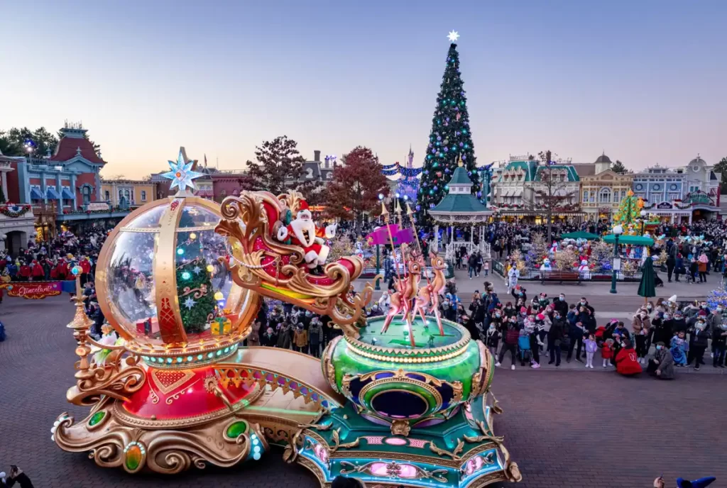 Papai Noel em carro alegórico natalino na Disneyland Paris com rena e árvore de Natal gigante