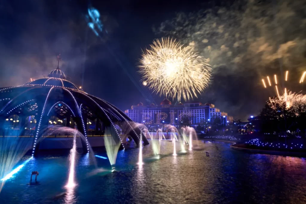 Estátua iluminada da deusa da lua no show de encerramento do Epic Universe com feixes de luz e cenário noturno