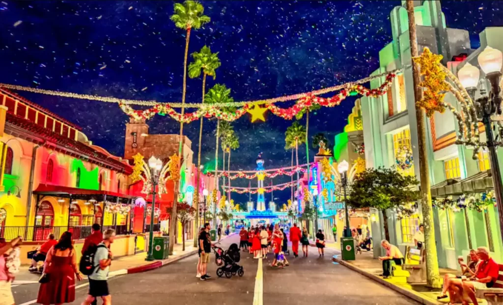 Ruas do Hollywood Studios decoradas com luzes natalinas e guirlandas.
