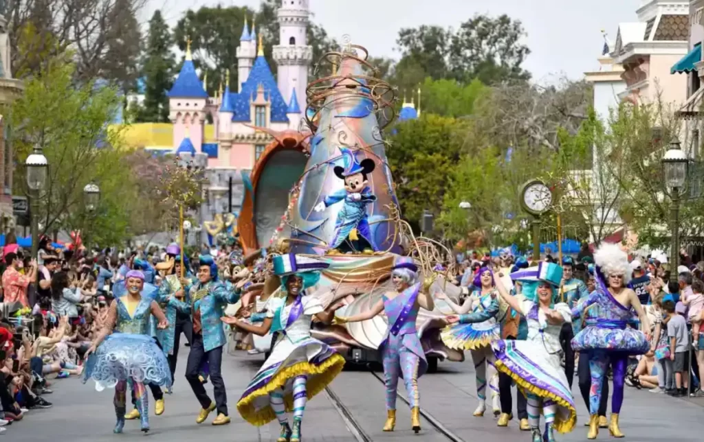 Mickey Mouse vestido de feiticeiro lidera o desfile Magic Happens em frente ao castelo da Disneyland.