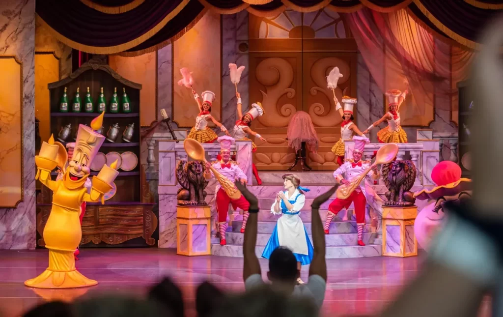 Show ao vivo A Bela e a Fera na Disney Hollywood Studios com personagens e figurinos coloridos no palco.