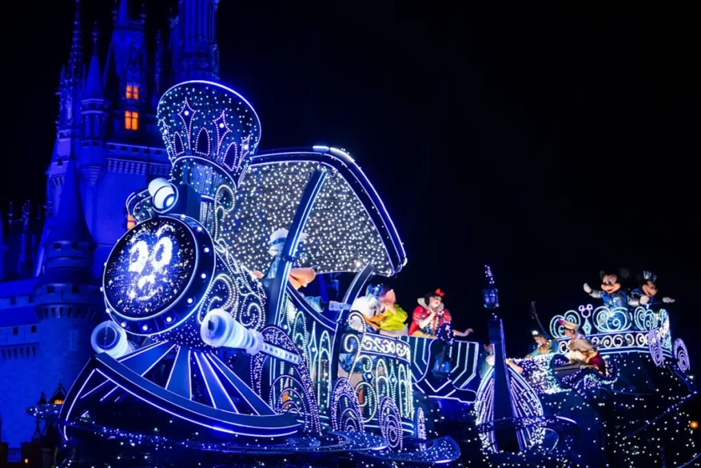Carro alegórico azul iluminado do desfile Disney Starlight Parade com Mickey e personagens clássicos em frente ao Castelo da Cinderela.