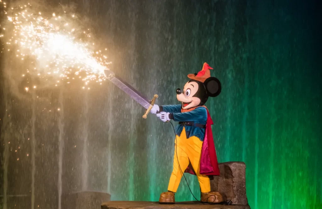 Mickey Mouse como aprendiz de feiticeiro empunhando uma espada com faíscas durante o espetáculo Fantasmic! da Disney em Orlando.