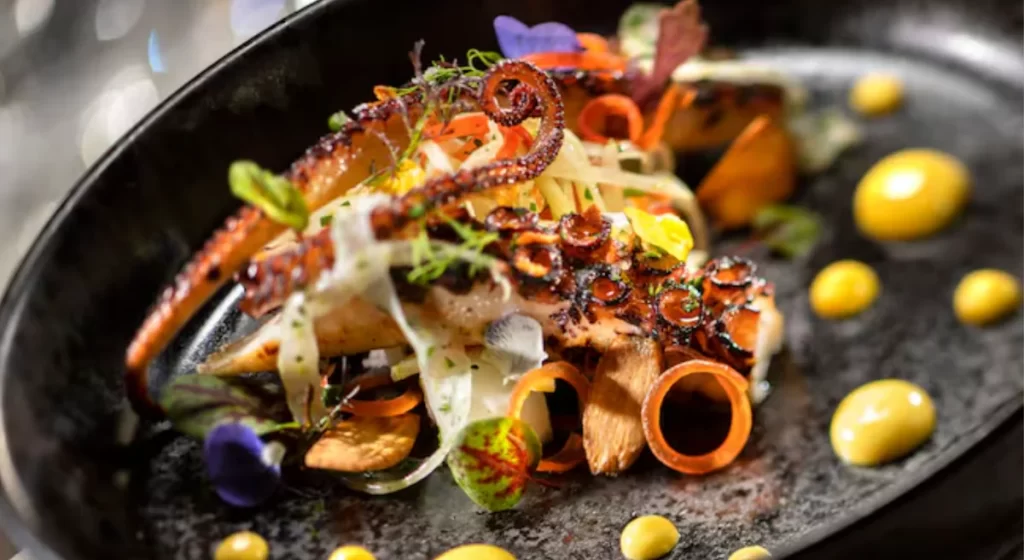 Prato gourmet de frutos do mar servido no restaurante Flying Fish do Disney BoardWalk, com apresentação refinada.