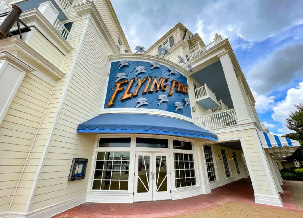 Entrada do restaurante Flying Fish no Disney BoardWalk, com fachada azul e decoração temática de peixes.