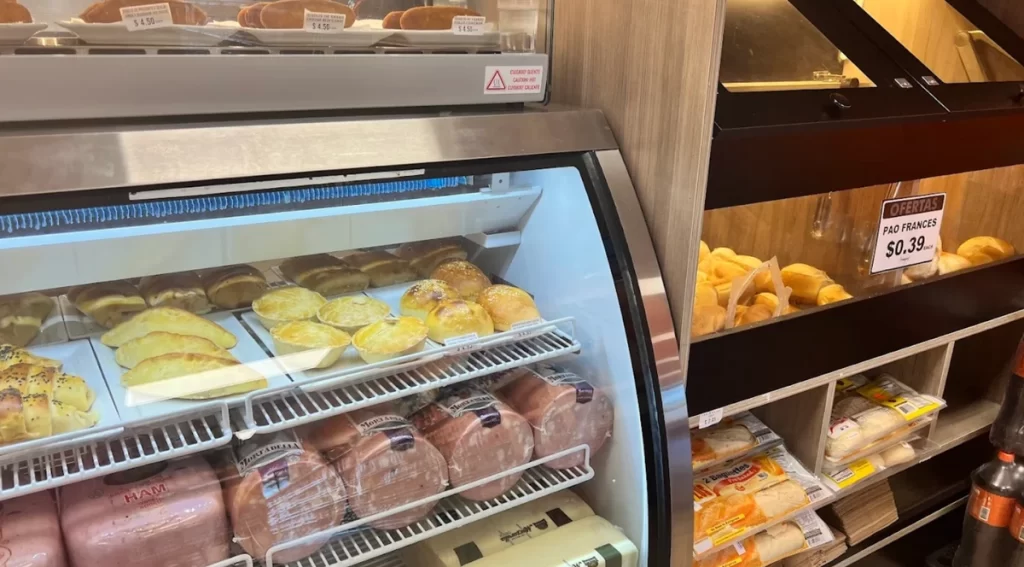 Vitrine refrigerada do Armazém X em Orlando com pães, frios e pão francês em oferta