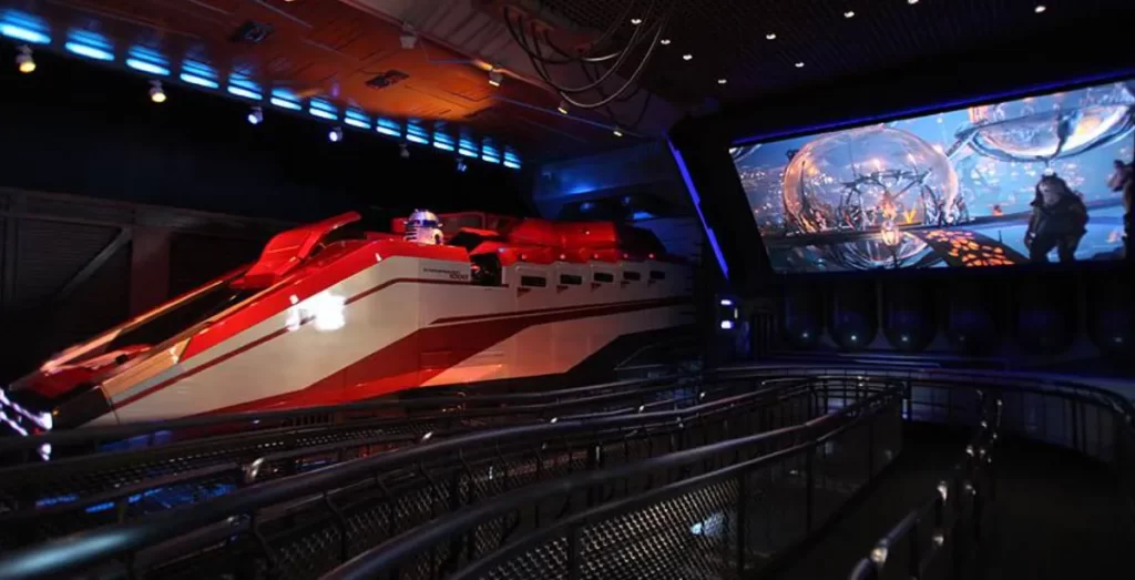 Simulador da atração Star Tours na Disney Hollywood Studios com R2-D2 e cenário futurista iluminado.