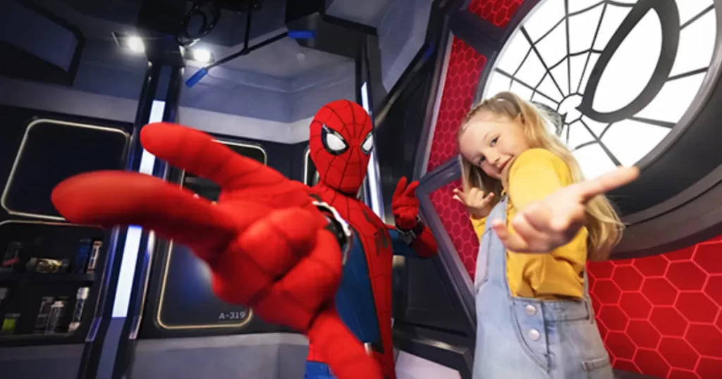 Homem-Aranha posa com visitante no Avengers Campus da Disneyland Paris, atração interativa e imersiva para toda a família.