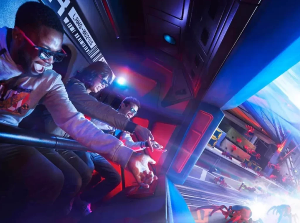 Visitantes jogam teias com óculos 3D na atração Spider-Man W.E.B. Adventure, simulador interativo no Avengers Campus, Disneyland Paris.