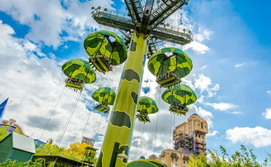 Brinquedo Toy Soldiers Parachute Drop no Toy Story Playland, Disneyland Paris, com visitantes descendo em paraquedas verdes temáticos.