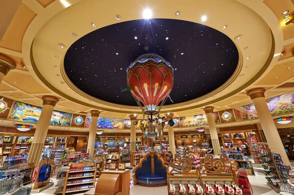 Interior da loja World of Disney com decoração temática e balão central no Disney Village Paris