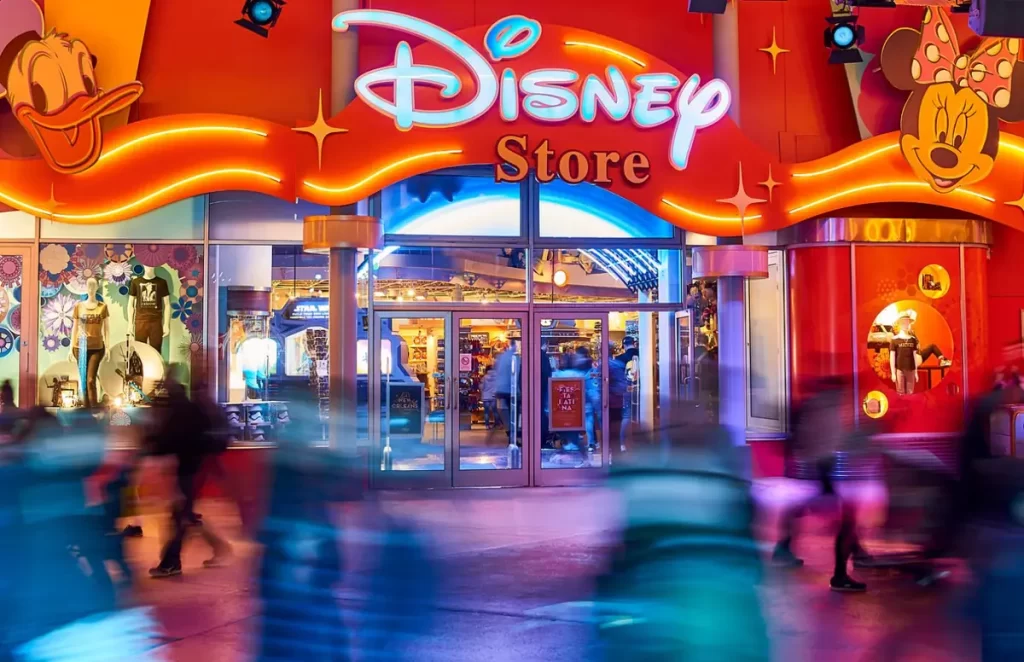 Fachada iluminada da Disney Store com personagens na entrada no Disney Village Paris