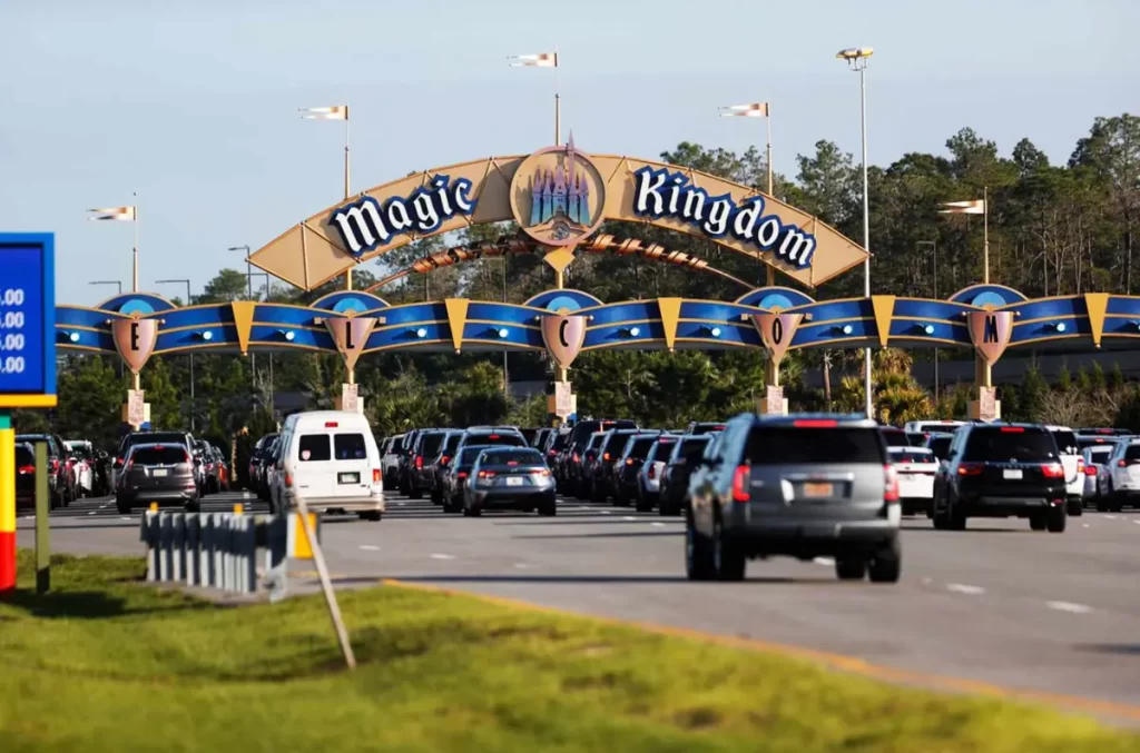 Estacionamento Magic Kingdom - Entrada principal do Magic Kingdom no Walt Disney World, com pórticos icônicos, cabines de acesso e veículos chegando ao parque