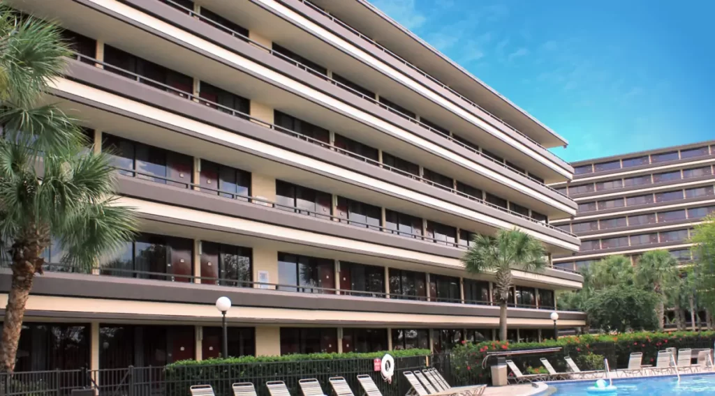 Fachada do Rosen Inn Pointe com varandas e piscina ao ar livre em primeiro plano.