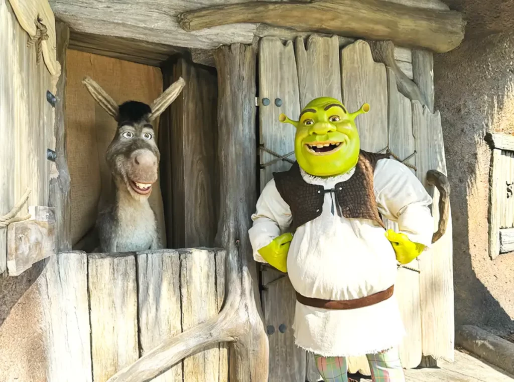 Shrek e Burro em frente à cabana do pântano durante encontro com personagens na Universal Studios.