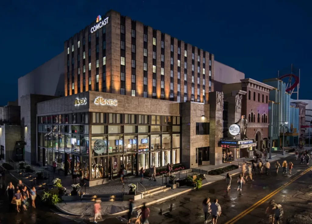 Fachada iluminada do prédio da NBC/Comcast na Universal Studios Hollywood à noite.
