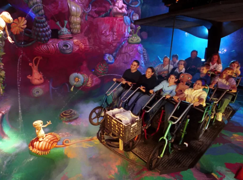 Entrada colorida da The Simpsons Ride com personagens no topo da estrutura.