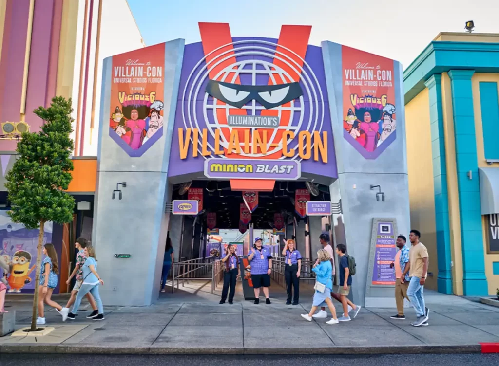Entrada da atração Villain-Con Minion Blast na Universal Studios Florida com visitantes passando.