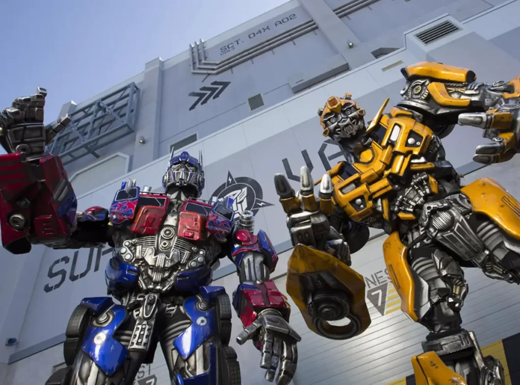 Fantasias realistas de Optimus Prime e Bumblebee em frente à atração Transformers na Universal Studios.