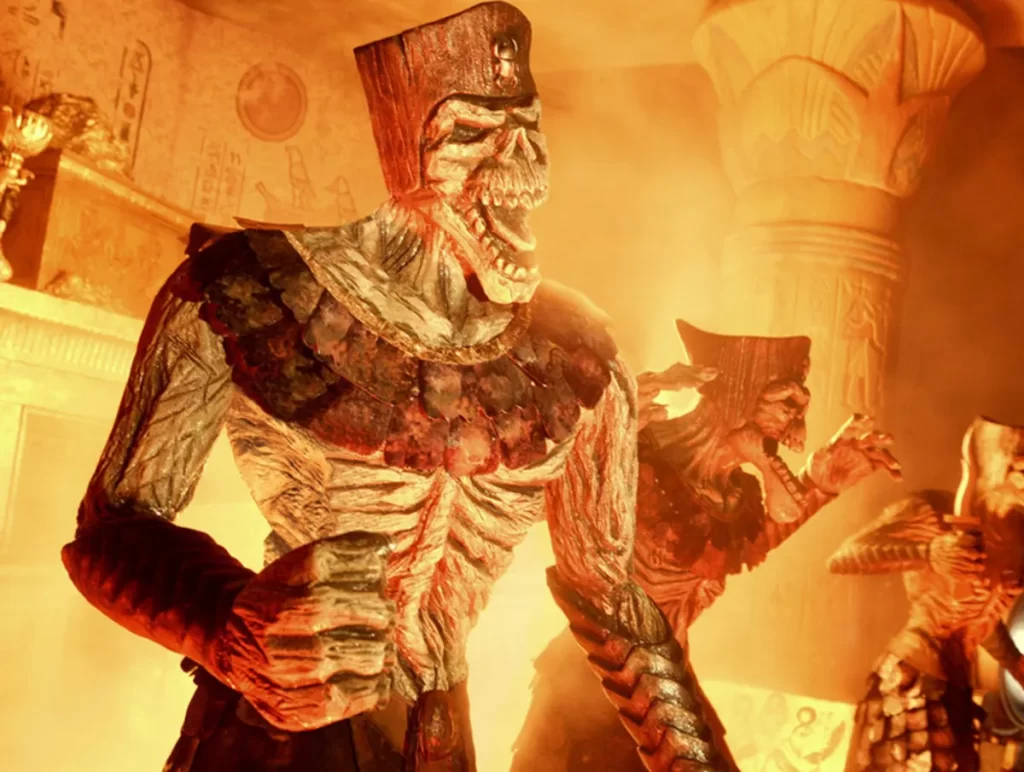 Animatrônicos de esqueletos em cena iluminada de fogo na atração Revenge of the Mummy.