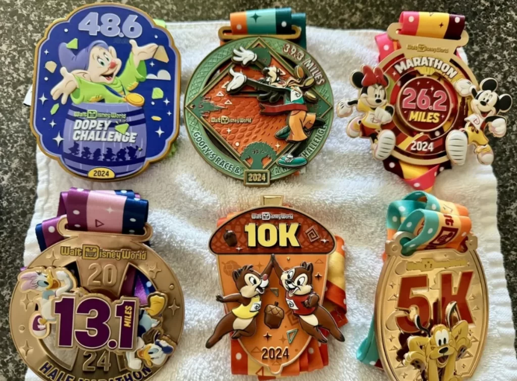 Medalhas oficiais do Disney Marathon Weekend, incluindo Dopey Challenge, Maratona 42K, Meia Maratona 21K e prova 10K, exibidas após o evento runDisney.