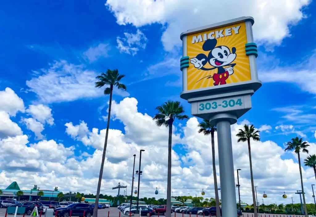 Placa do Estacionamento Mickey no Disney’s Hollywood Studios, com palmeiras, céu azul e carros estacionados em Orlando.