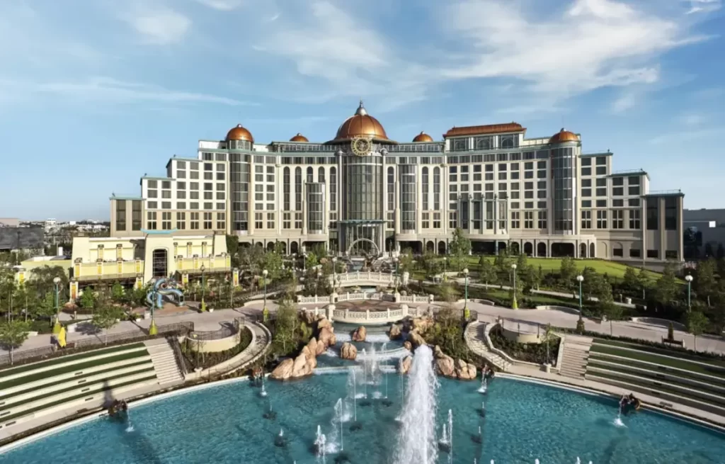 Fachada do Helios Grand Hotel Epic Universe Orlando, hotel premium com arquitetura elegante e jardins com fontes