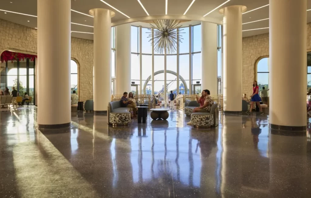 Lobby do Helios Grand Hotel no Epic Universe Orlando, com pé-direito alto, colunas imponentes e decoração contemporânea