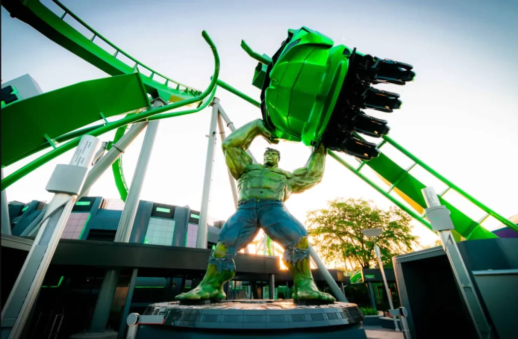 Estátua gigante do Hulk segurando trilho da montanha russa Hulk no Islands of Adventure em Orlando com carrinho verde passando em alta velocidade atração radical Universal Orlando