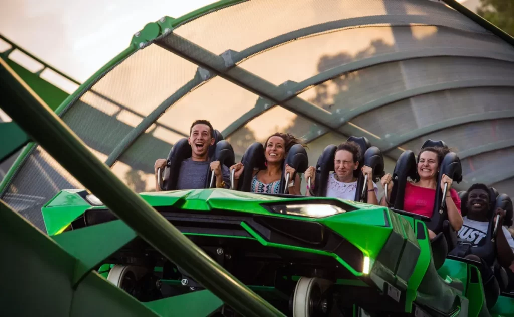 Montanha Russa Hulk com carrinho verde em alta velocidade na descida inicial com pessoas gritando no brinquedo radical do parque Islands of Adventure em Orlando Universal Studios