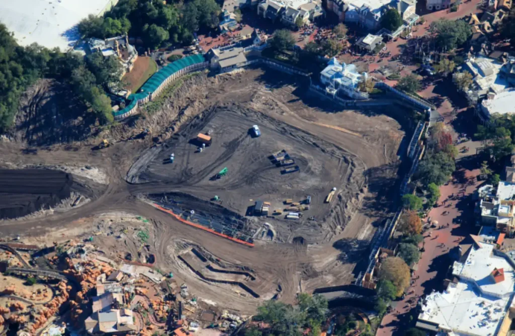 Construção em andamento no Magic Kingdom, da Disney, revela área escavada para futura atração temática com infraestrutura pesada e preparação do terreno.