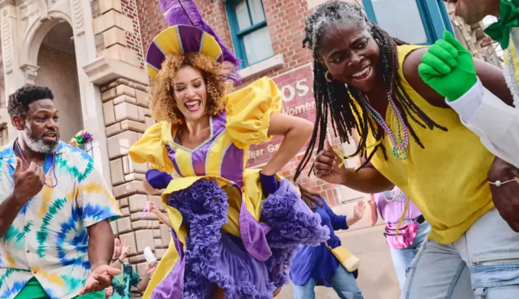 Performers fantasiados dançando no Mardi Gras da Universal Orlando com roupas coloridas