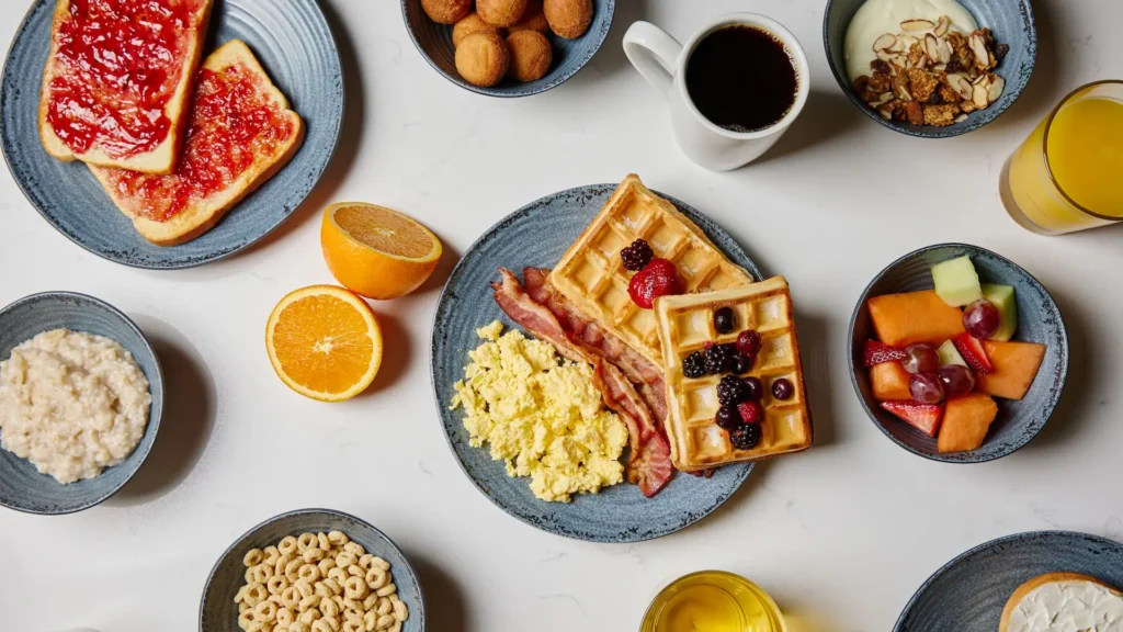 Prato com waffles, ovos, bacon e frutas no café da manhã do Monreale Express International Drive