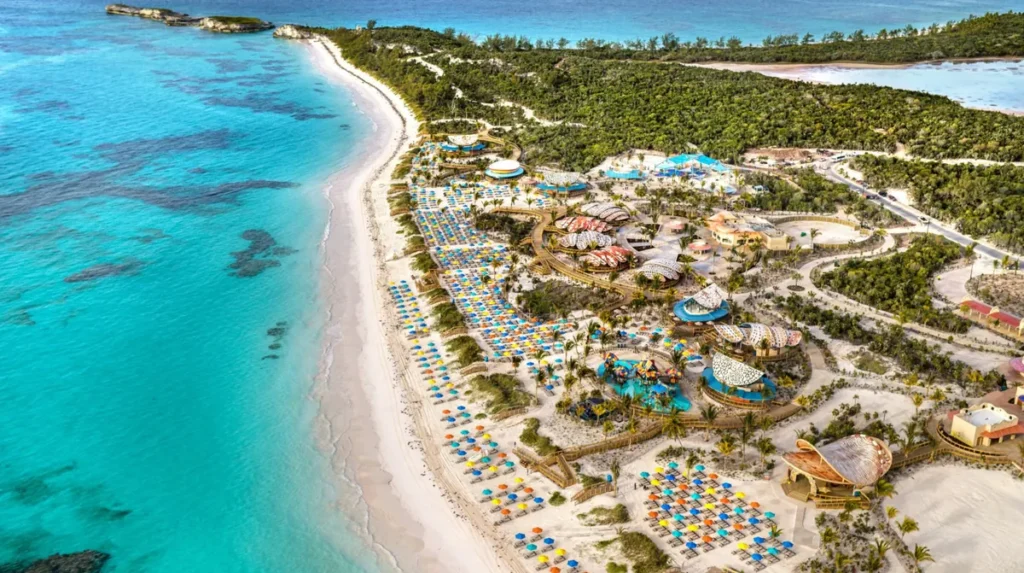 Vista aérea da ilha privada da Disney nas Bahamas com praia de areia branca, mar azul-turquesa e estruturas de lazer.